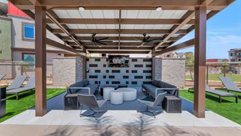 a covered patio with couches and chairs and a fireplace at Weylyn Luxury Apartments, Arizona